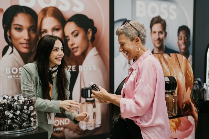 Gäste im Gespräch an einem Beauty-Produktstand