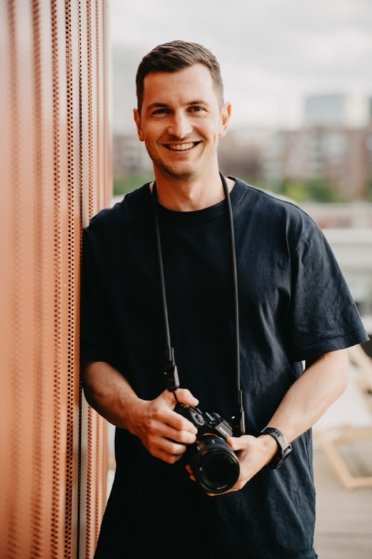 Fotograf Ken Stüker mit Kamera auf einer Dachterrasse