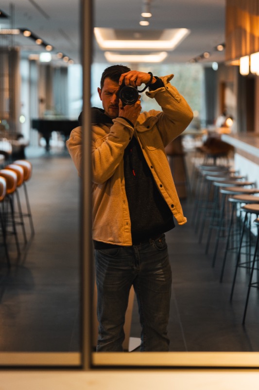 Ken Stüker fotografiert sein Spiegelbild in einer Hotellobby